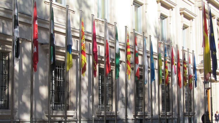 Las banderas de las Comunidades Autónomas ondean delante del Palacio del Senado.